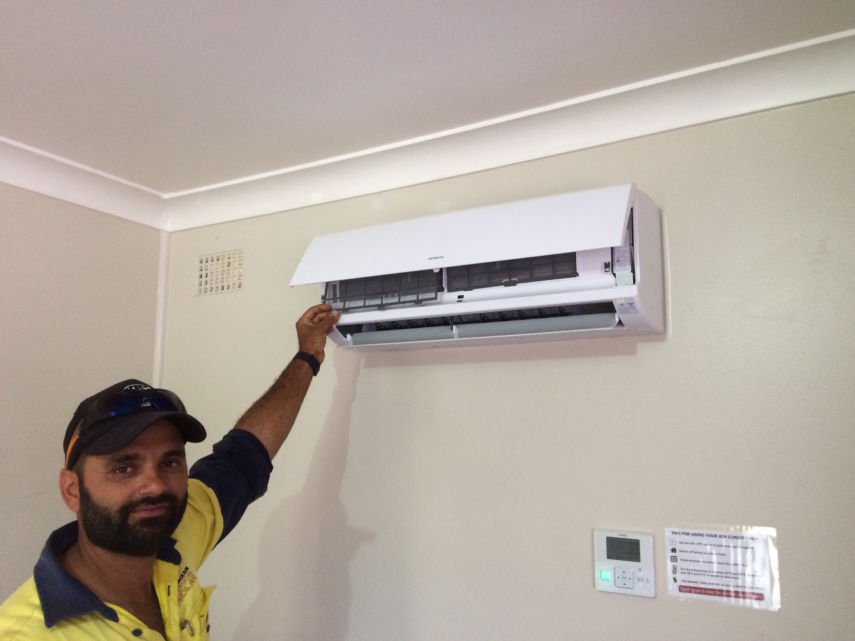 Image of a contractor installing a new air conditioner in a Land and Housing Corporation property