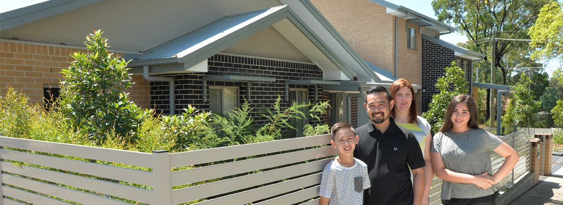 Family standing in front of home