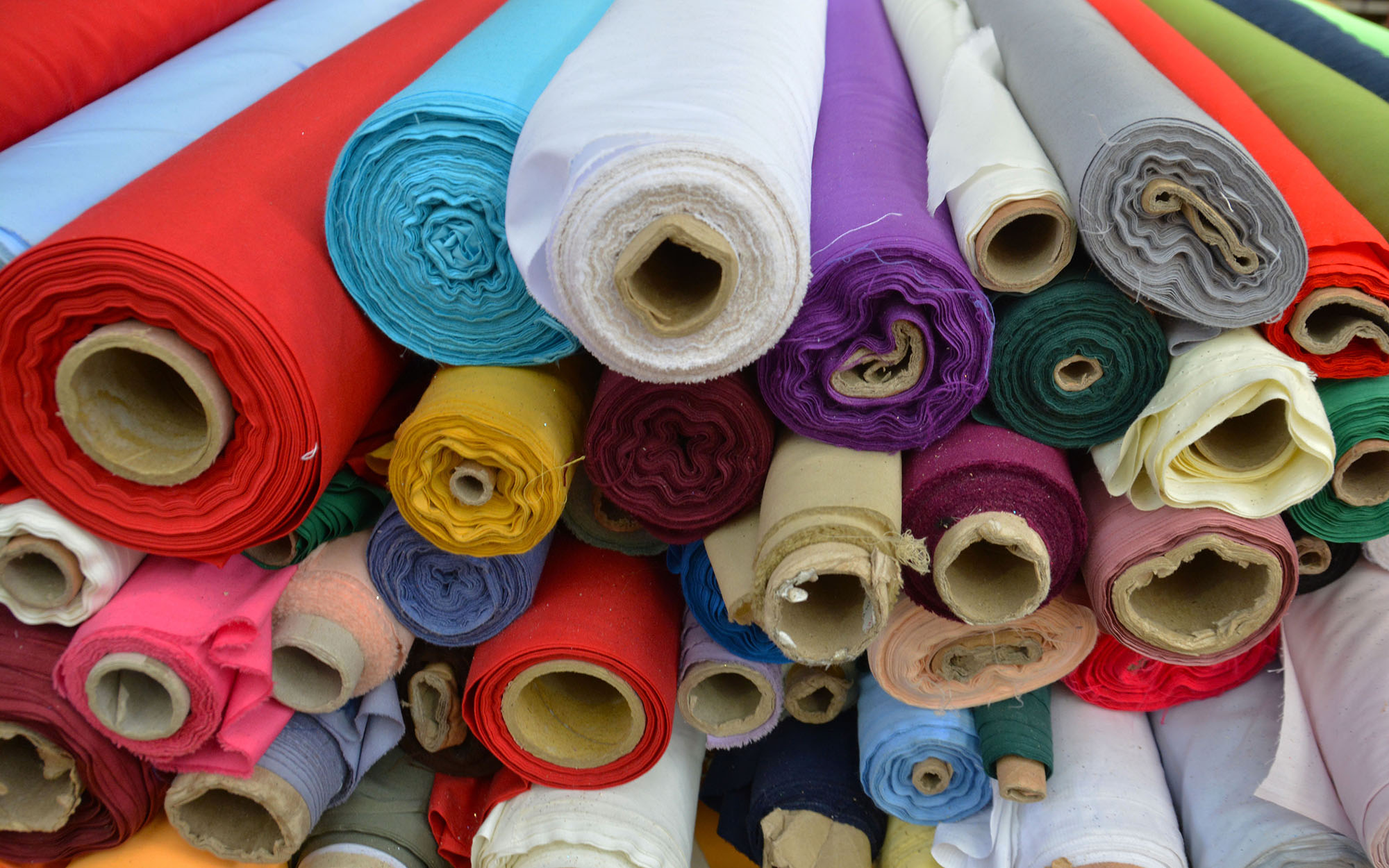 A heap of colourful roles of textiles 