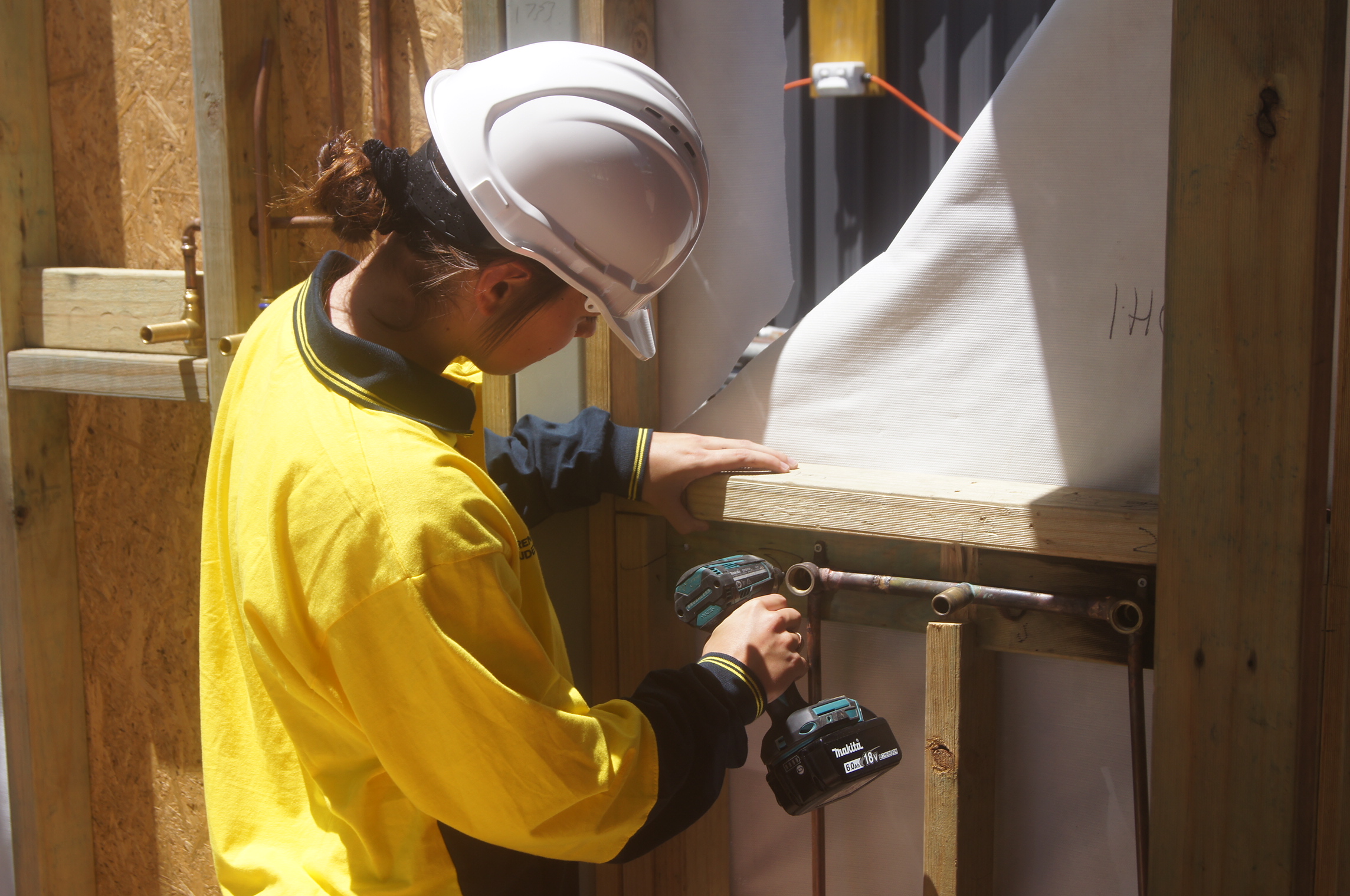Image of a female apprentice at work on construction site