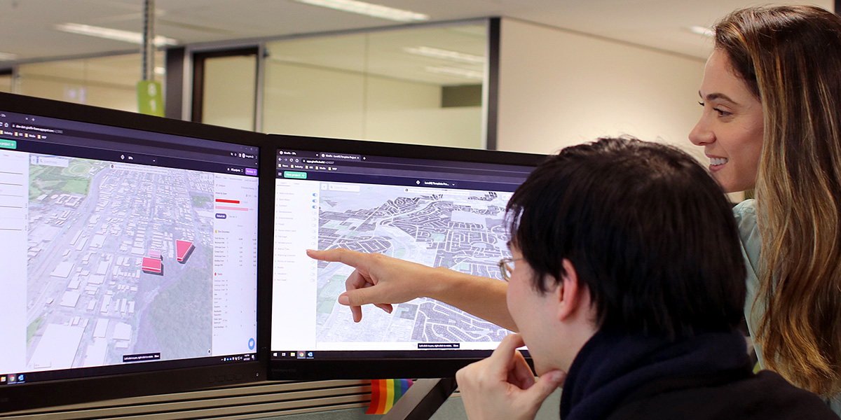 People looking at Land iQ on dual desktop screens