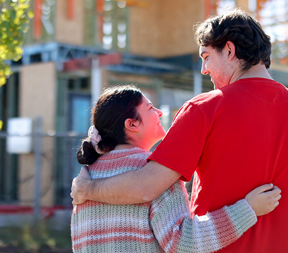 First home buyers together at building site.